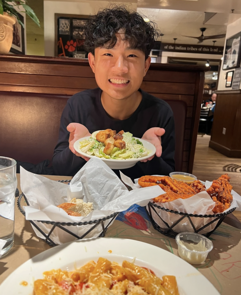 A very happy person holding a delicious bowl of salad