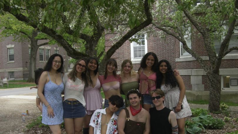 A group photo of students under blossoming trees 