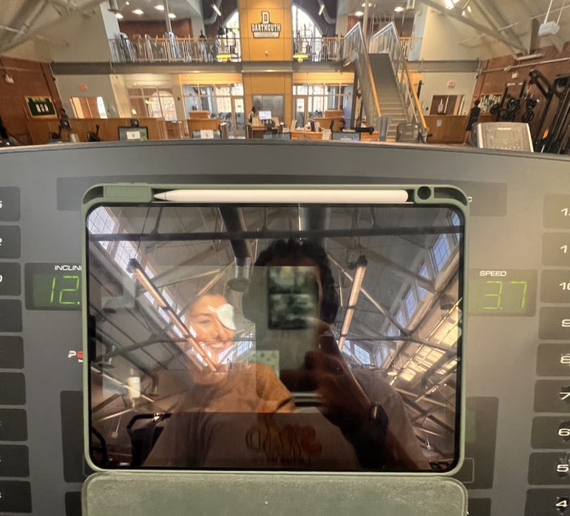 Blogger's selfie in iPad reflection while watching a course assignment on the treadmill.