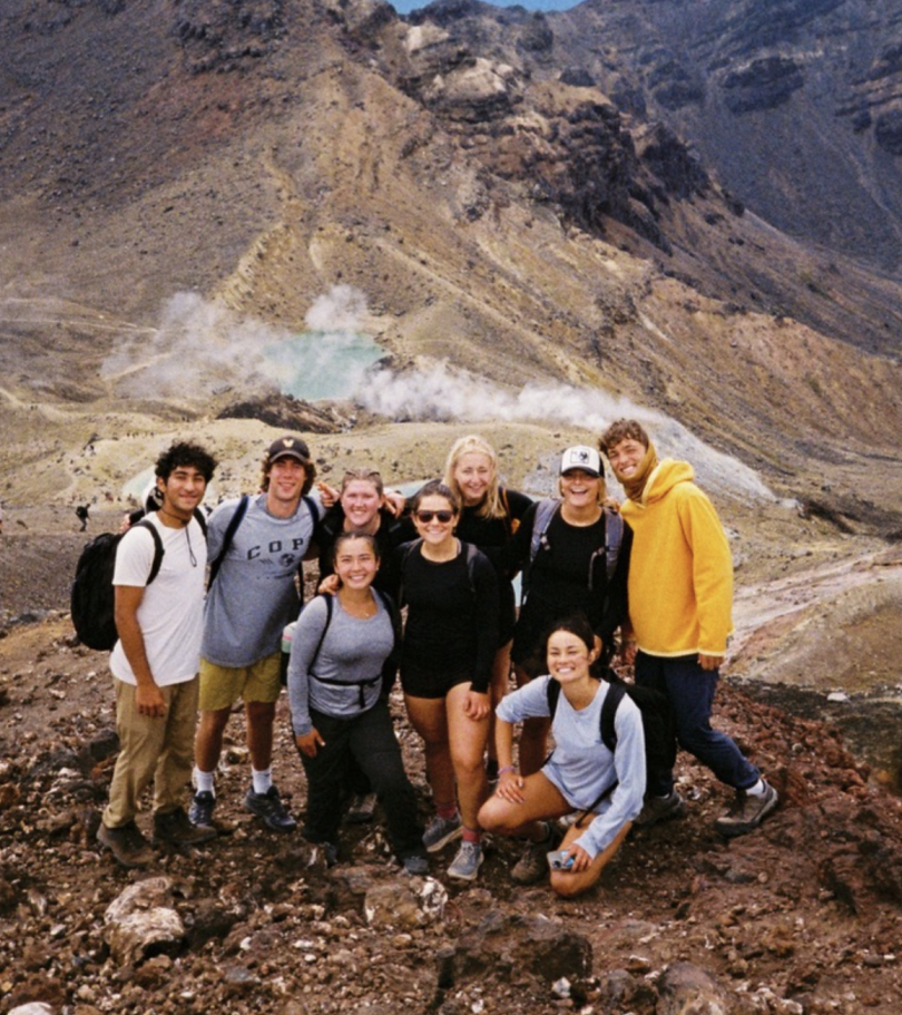 group of students smiling at the top of a mountain