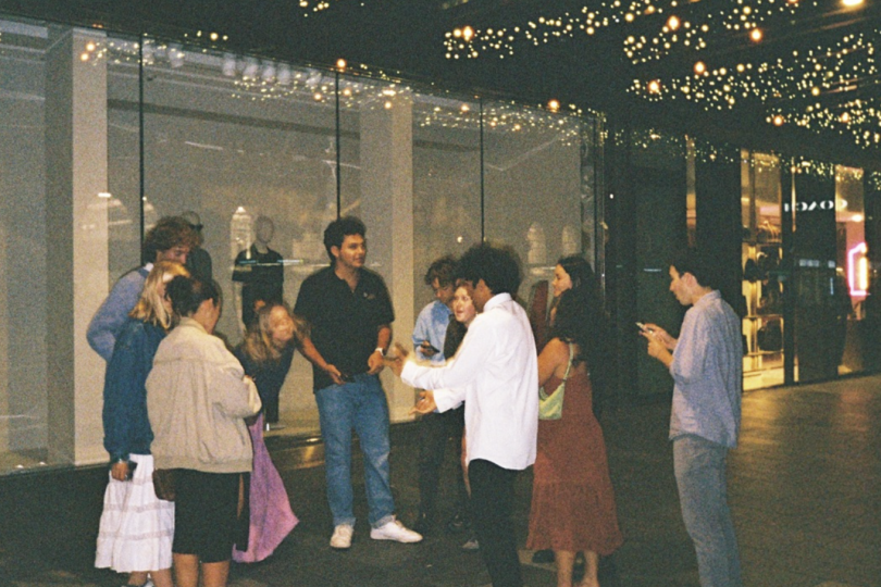 students standing in a street saying goodbye