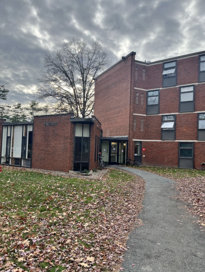 The front of French Hall is a red/brown brick building. The left side is only one floor, where the common room and kitchen are. The right side goes up to four floors and are where all the rooms are. In front of the building are fallen leaves and a cement
