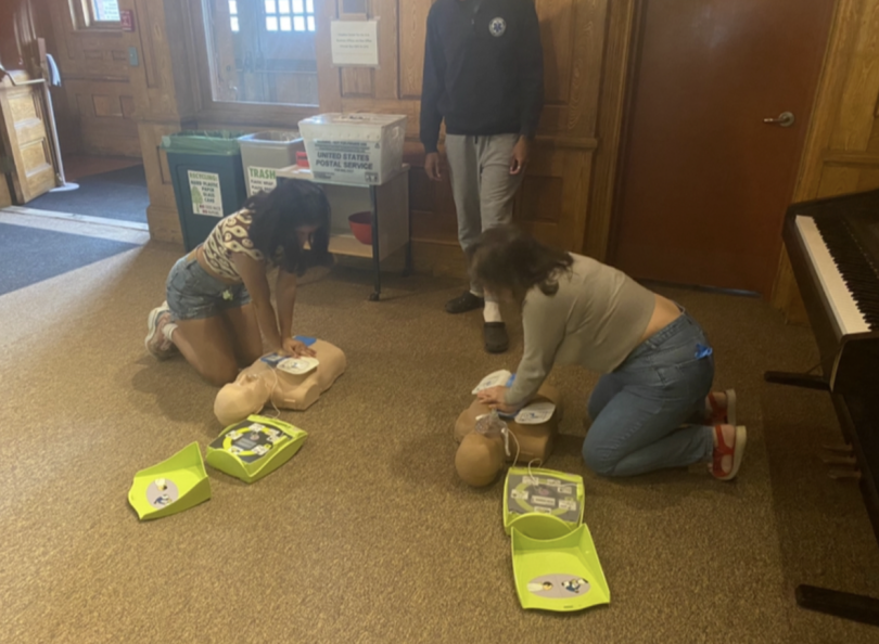 A picture of two MAPS members doing CPR on mannequins while a DEMS trainer watches.
