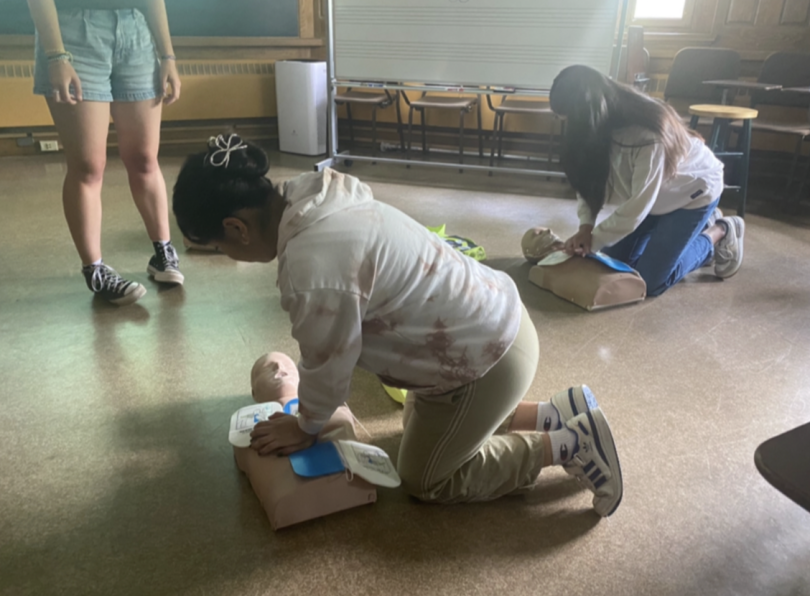 A picture of two MAPS members doing CPR on mannequins while a DEMS trainer watches.