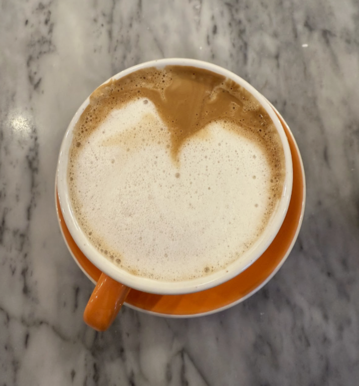 a cappuccino in an orange mug.