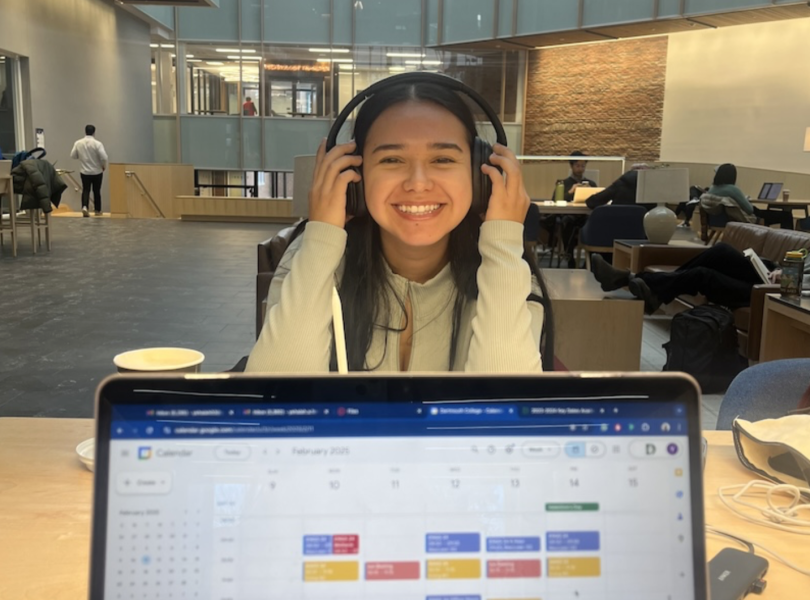 An image of a laptop open to Google Calendar, with a student smiling in the background