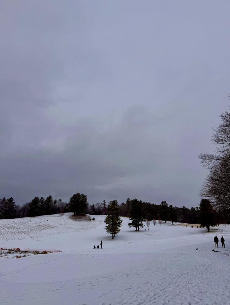 landscape with hills covered in snow with people walking around