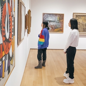 A photo of students in the Hoood Museum of Art looking at work on the wall
