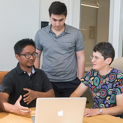 A photo of students and a professor discussing a project