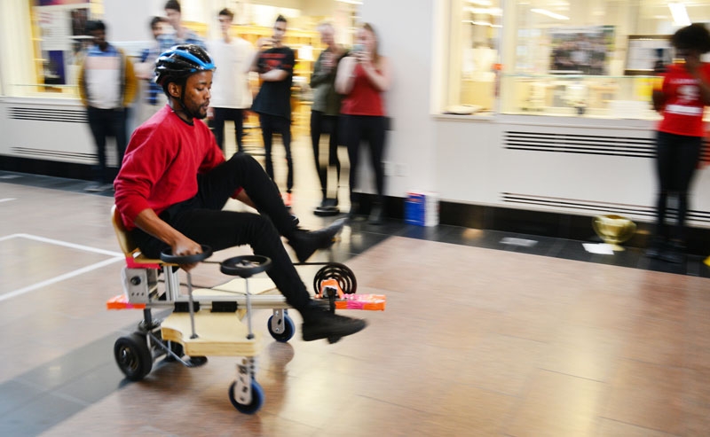 A photo of a student riding an omnidirectional vehicle