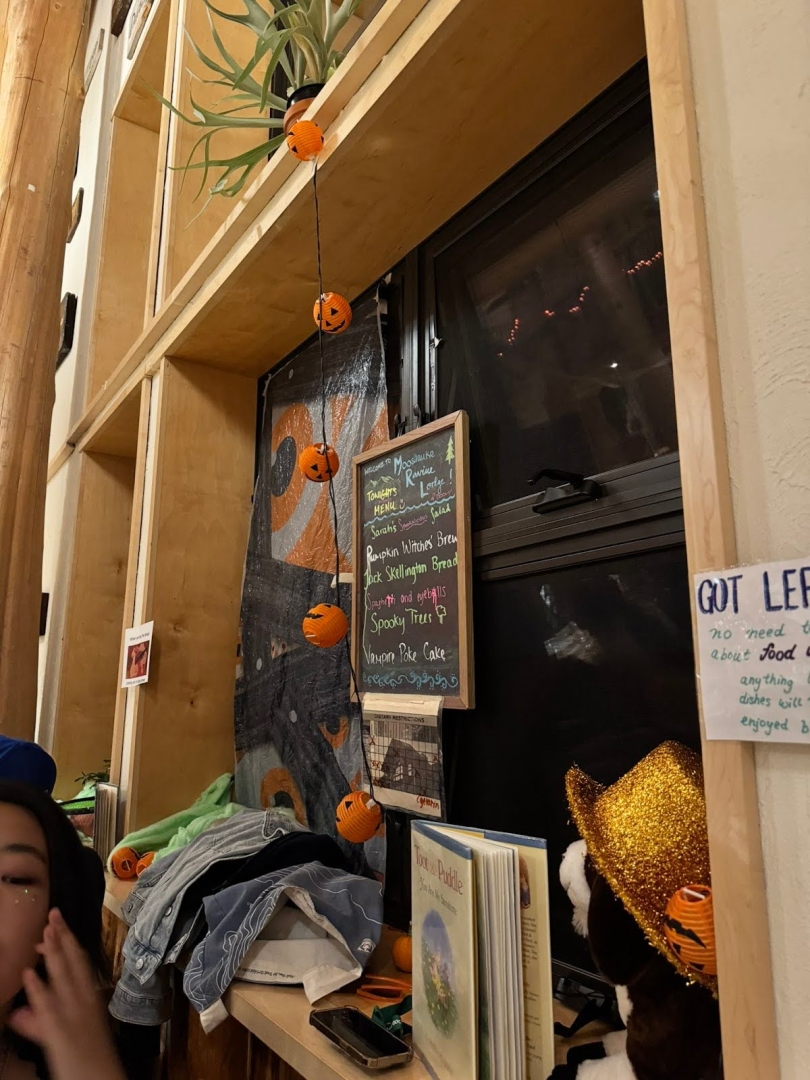 A photo of a window at the Lodge. There are many trinkets, like a book, phone, and jacket sitting on the windowsill. The menu for dinner, written in colorful chalk, is partially visible.