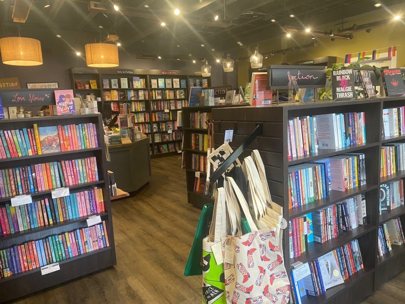 A bookstore with several shelves, all filled with neatly arranged books.