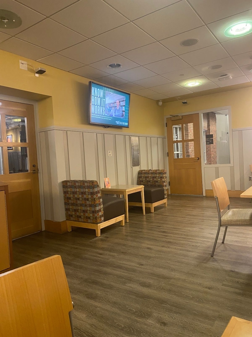 Two sofas and a coffee table with a television on the wall above. There are two doors on either side of the sofas.