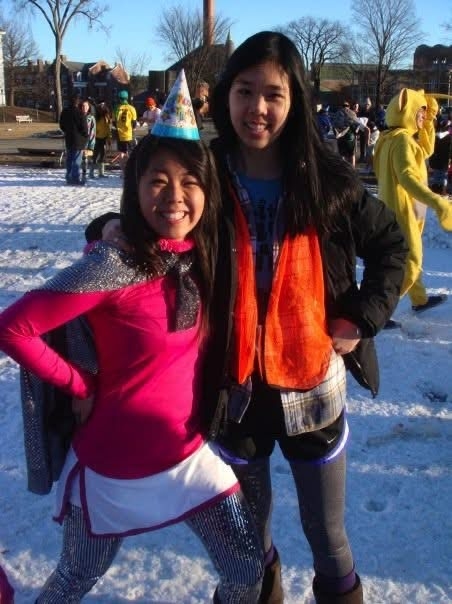 two women stand in colorful outfits on snow