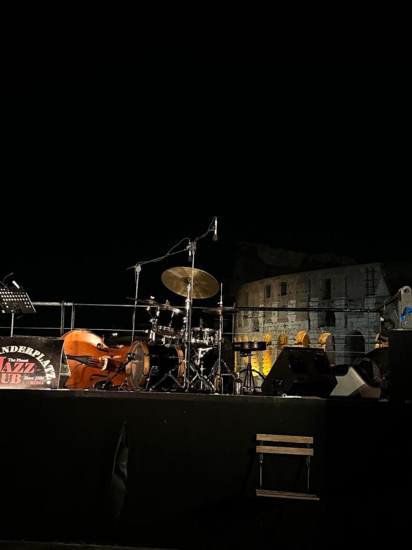 A stage with a jazz band set up with the Colosseum visible in the background.