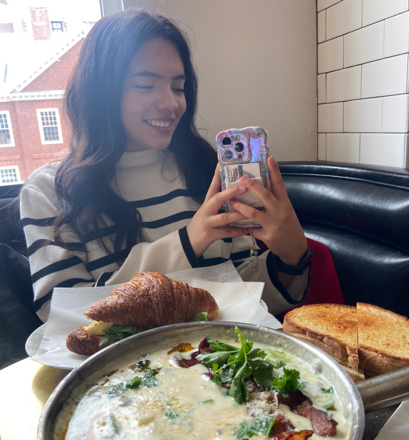 girl smiling with her phone in front while the photo is being taken