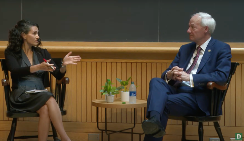 a man and a woman sit in a classroom talking