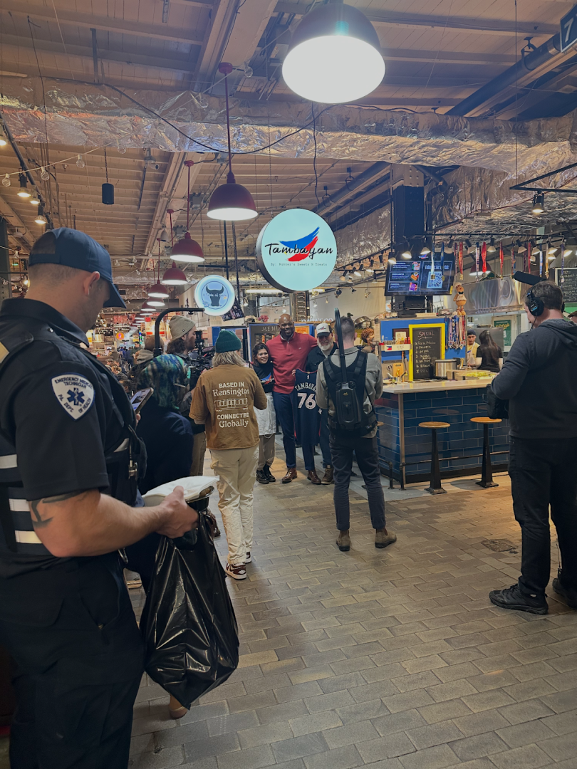 Picture of a market with people walking in it. 