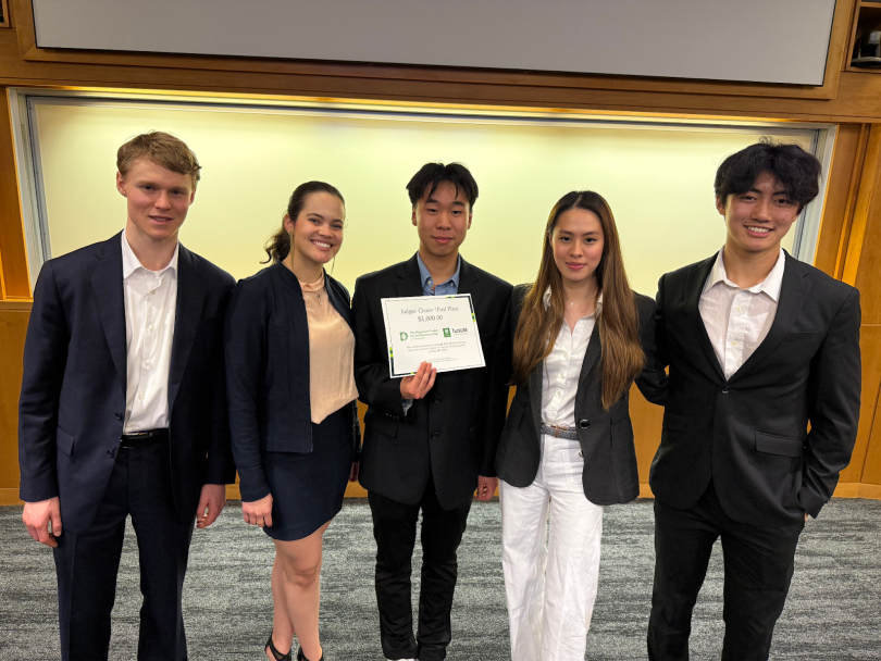 5 people smiling, with the middle one holding the Startup Competition award
