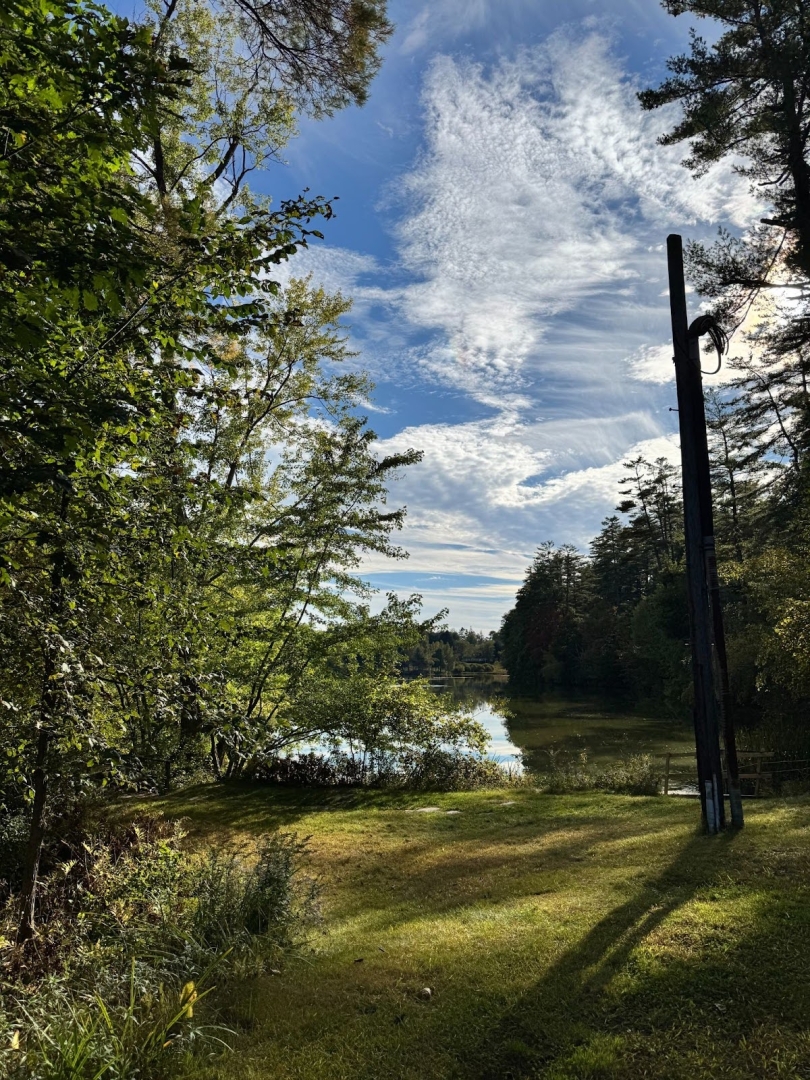 Occom Pond on a sunny early summer day, with lots of green grass and trees