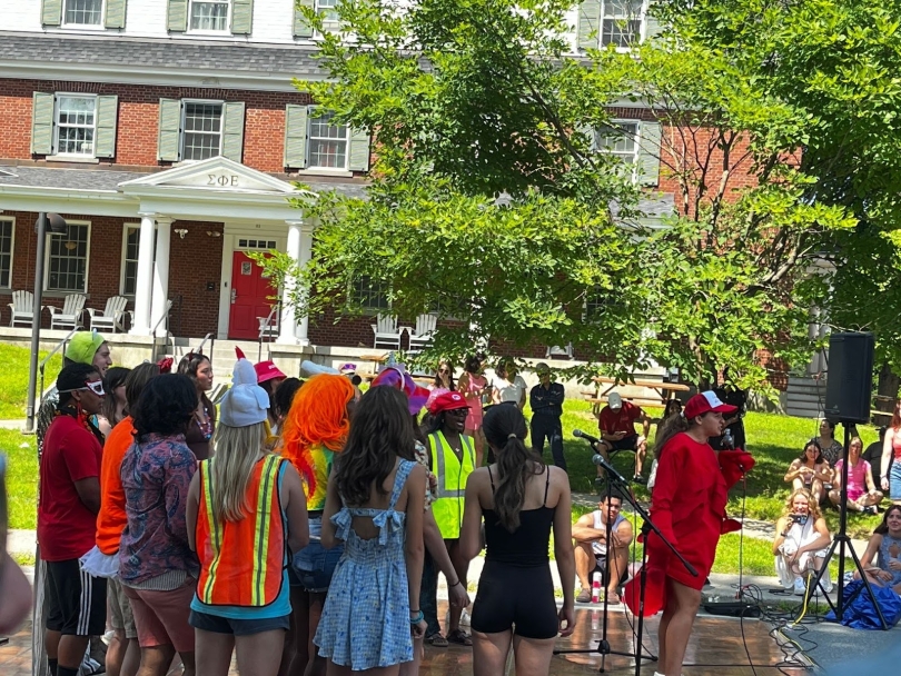 A group of people singing on a street stage in front of a sign that says "Street Fest"