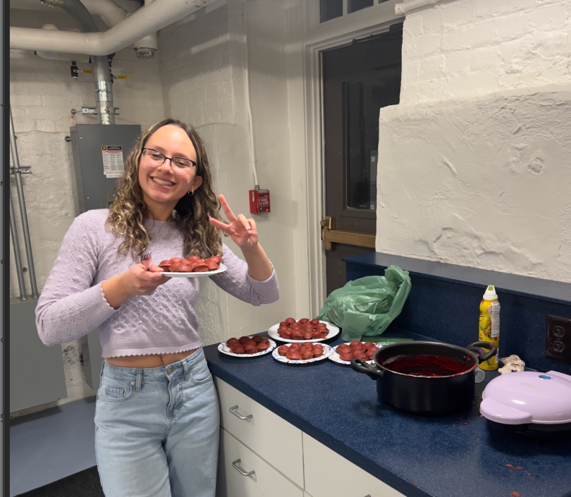 girl smiling and holding a plate of red velvet cupcakes