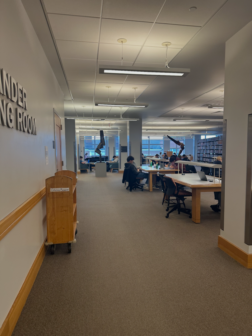 Picture of a carpeted library with people working at desks.