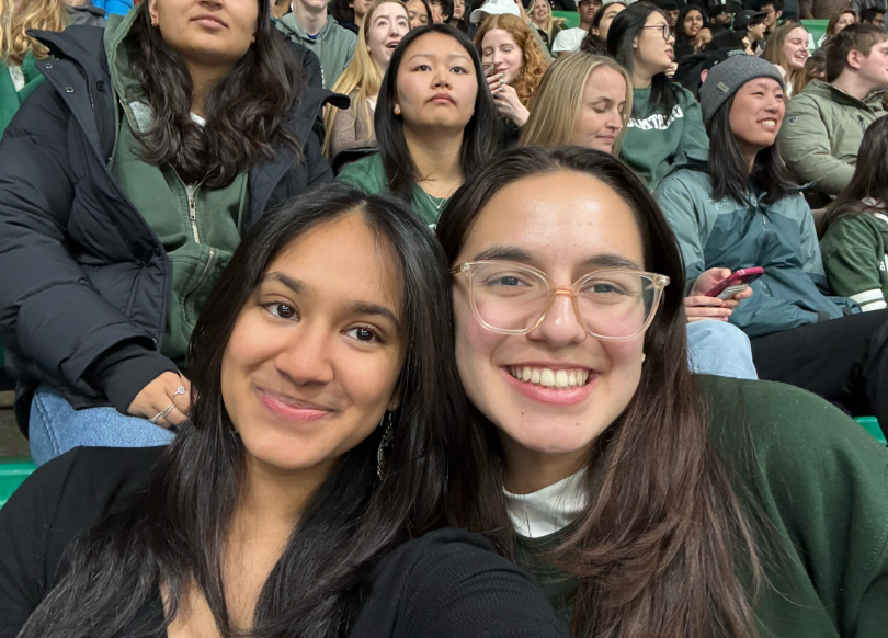 Selfie of two girls watching Princeton v. Dartmouth hockey game in a packed stadium.