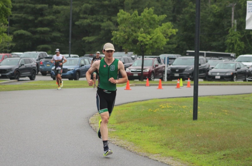 An image of a Dartmouth triathlete striding along the run course marked by cones.