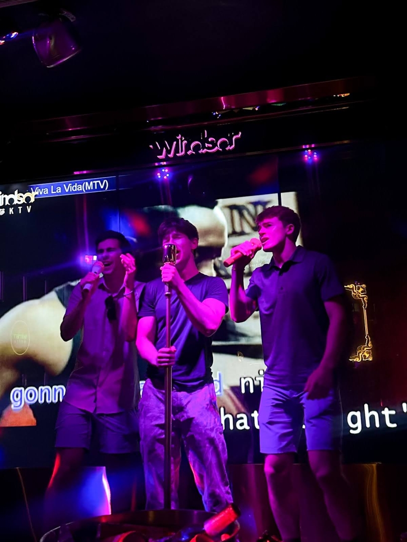 3 boys on a karaoke stage singing