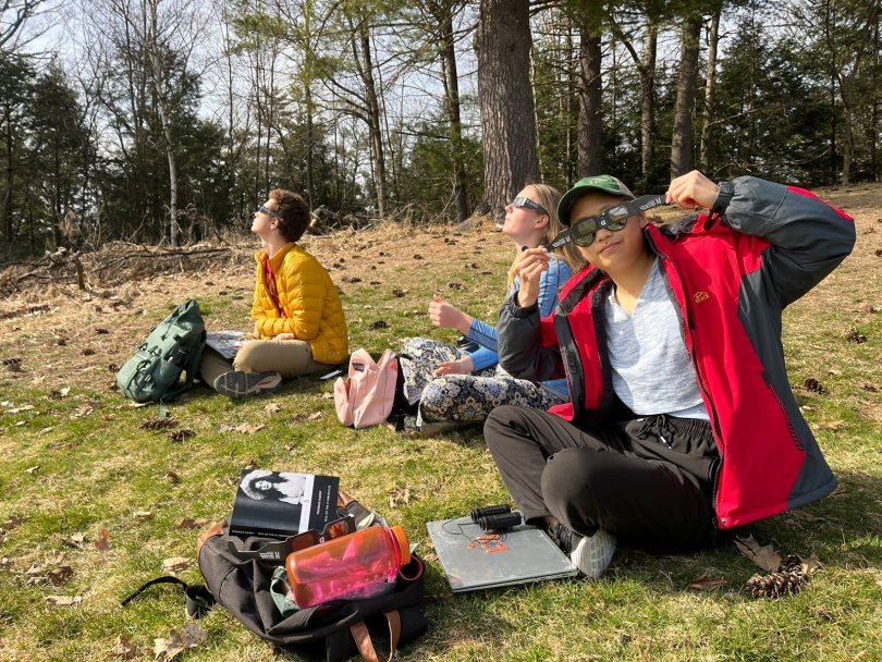 Lily and two of her friends watching the solar eclipse in Pine Park with our backpacks and school supplies.