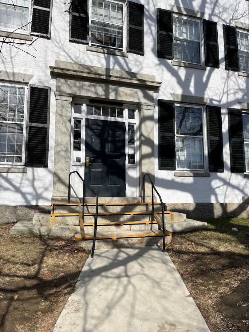 The door to Reed Hall during winter. There are many shadows from tree branches on the door.