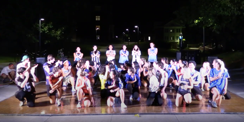 a group of dancers from the group Ujimelt kneeling on a stage