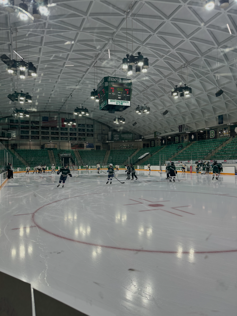 Picture of an ice rink with hockey players skating on it.