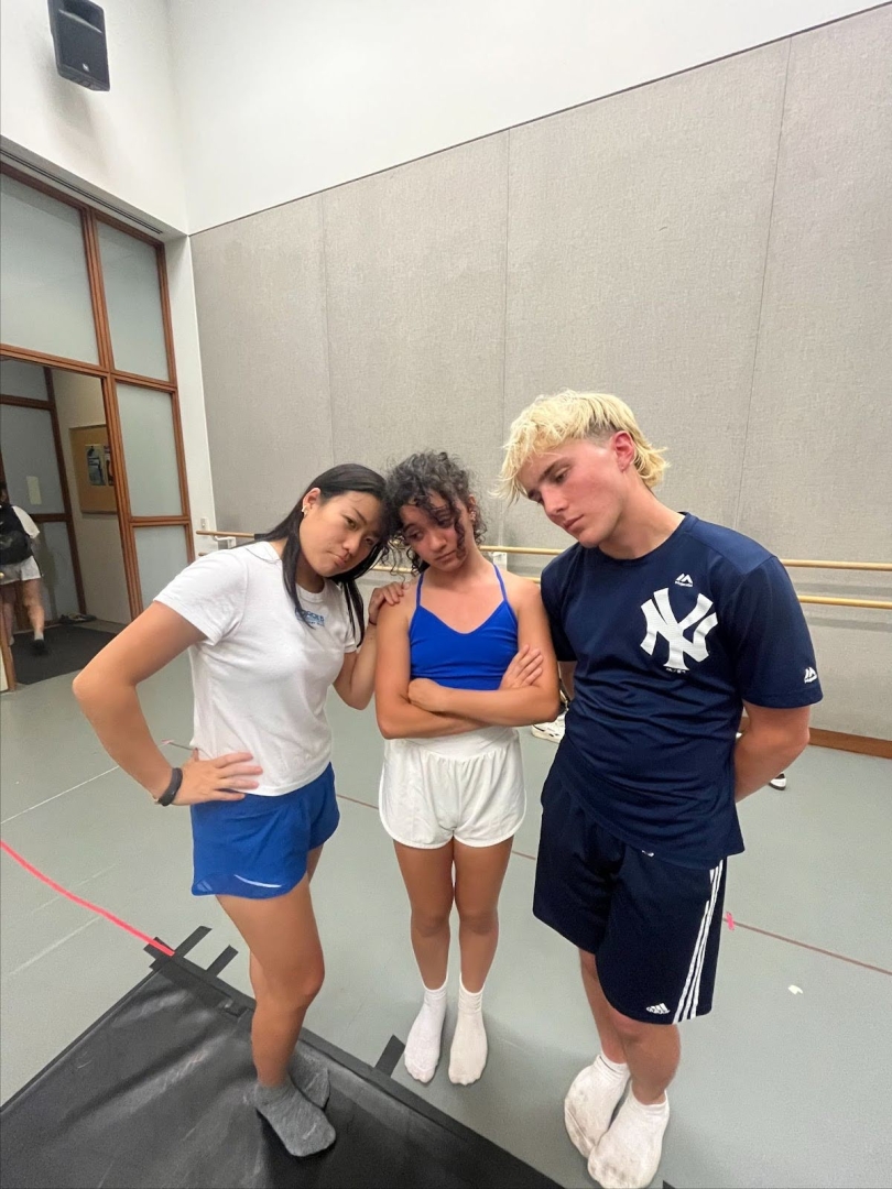 A group of three people looking sad while dressed in blue.