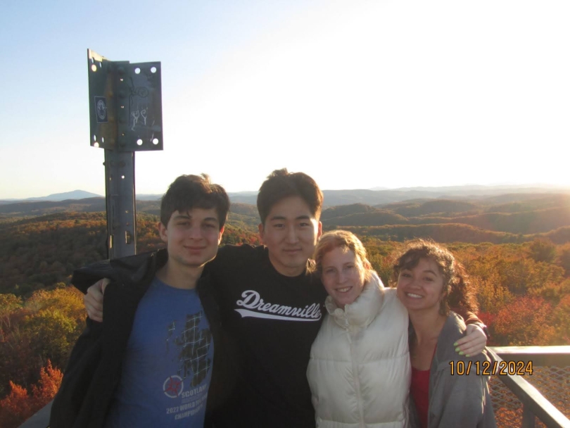 Four people standing in front of a vibrant red and orange horizon.