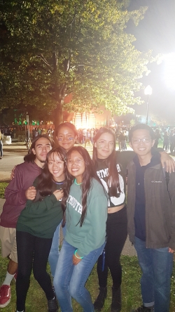 a group of students posing for a photo in front of the homecoming bonfire