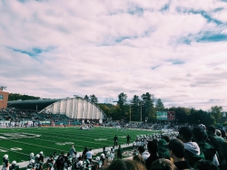 A view of the football field from the student section on a bright, fall day.
