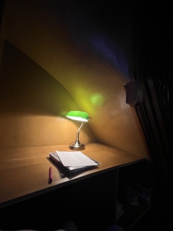 a linguistics data set on a wooden table under a green lamp