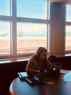 Nicole at table by window with books