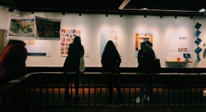 A picture taken from behind of 3 people observing the Fairbanks exhibits