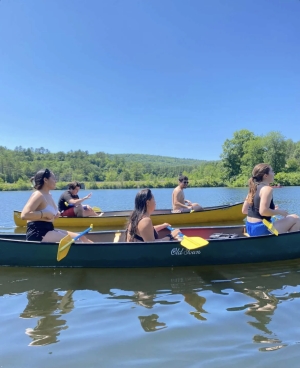 Gabriel '23 and Alvin '23 on a canoe behind Raylen '24, Hope '20, and Montana '24.