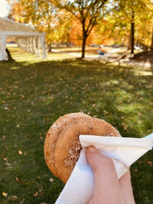 me holding two donuts in a napkin on baker lawn