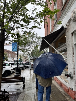 A photo of my Papa holding a blue umbrella in front of the Dartmouth Co-op