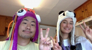 Two people wearing animal hats sitting next to each other. 