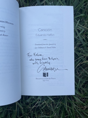 a picture of Eduardo Halfon's book propped open on the grass, so that his message to Kalina and signature are visible