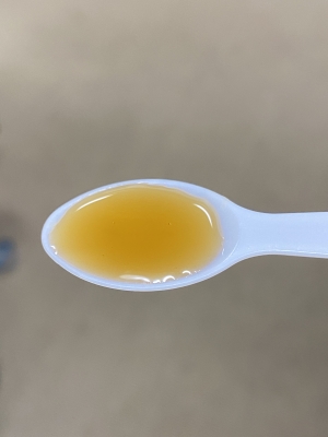 A spoonful of light brown, translucent syrup.