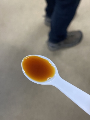 A spoonful of amber colored syrup.