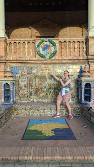 Lily pointing at the Santander tile monument at the Plaza de Espana