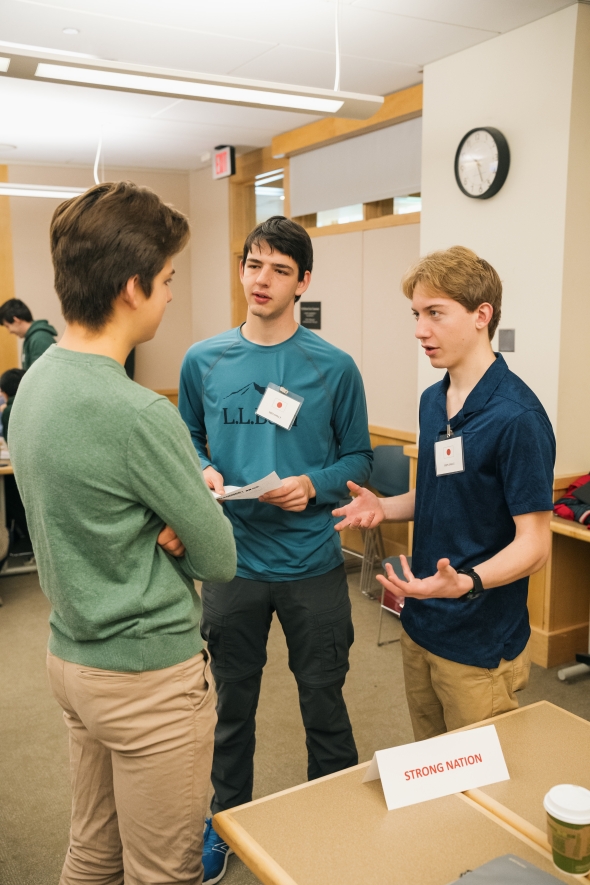 Three students discuss options during a wargaming simulation. 